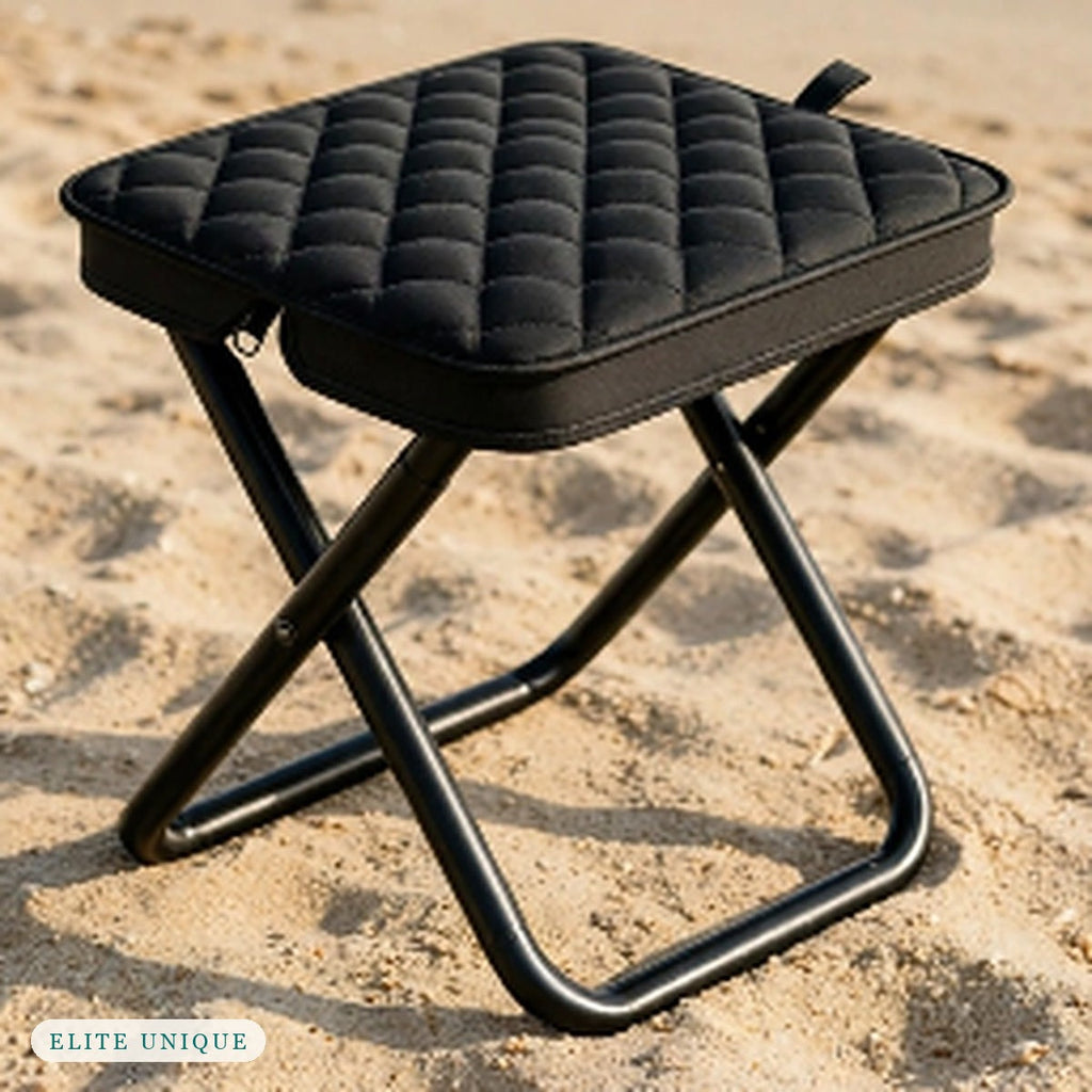 Compact Folding Stool in black standing on the sand
