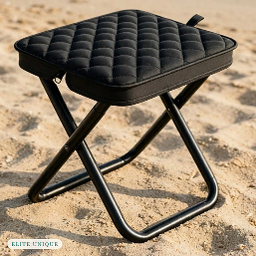 Compact Folding Stool in black standing on the sand