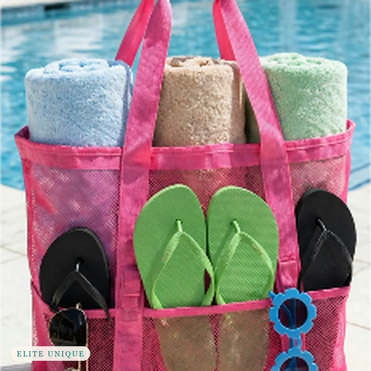 Large Mesh Beach Tote in hot pink by a pool, packed with towels, flip-flops and sunglasses