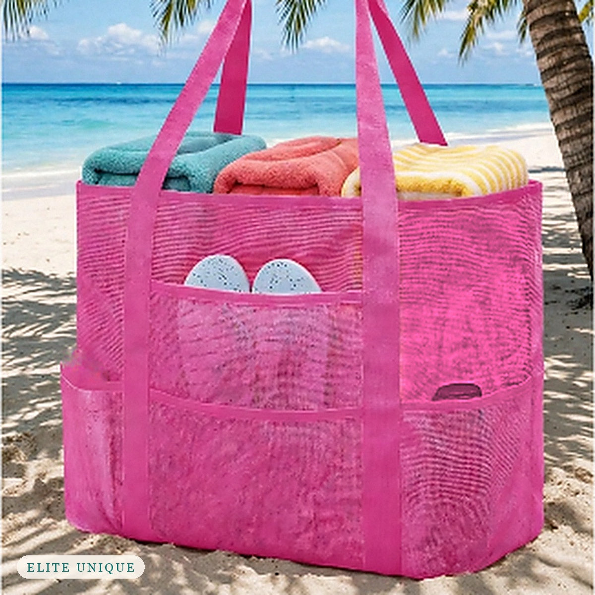 Large Mesh Beach Tote in hot pink on the beach, packed with towels