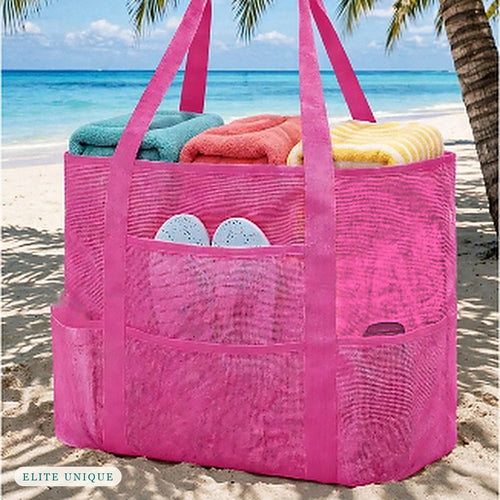 Large Mesh Beach Tote in hot pink on the beach, packed with towels